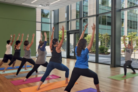 Participants standing in forward lunges, arm stretched up towards the ceiling Participants standing in forward lunges, arm stretched up towards the ceiling